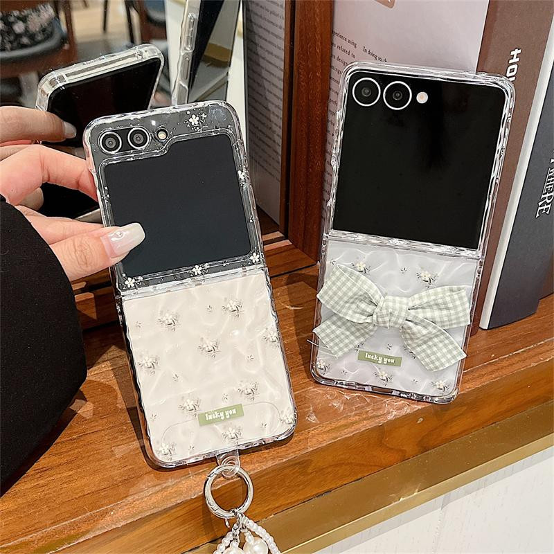 Transparente Samsung Galaxy Z Flip 6 und Z Flip 7 Handyhülle mit Wasserwellen-Blumen-Design und Perlenarmband-Schleife als Hartschalenabdeckung - Bild 2