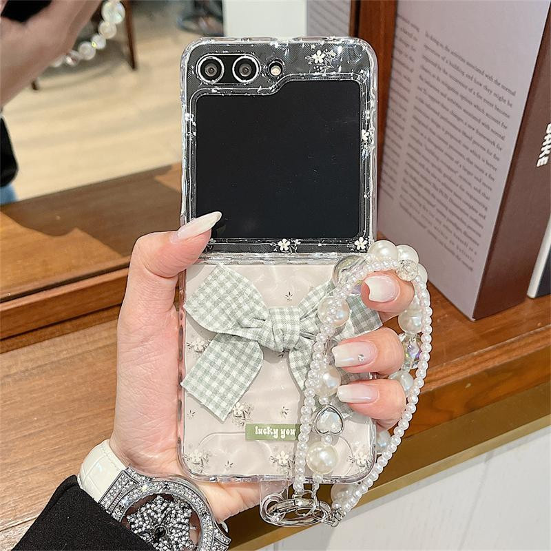 Transparente Samsung Galaxy Z Flip 6 und Z Flip 7 Handyhülle mit Wasserwellen-Blumen-Design und Perlenarmband-Schleife als Hartschalenabdeckung - Bild 1