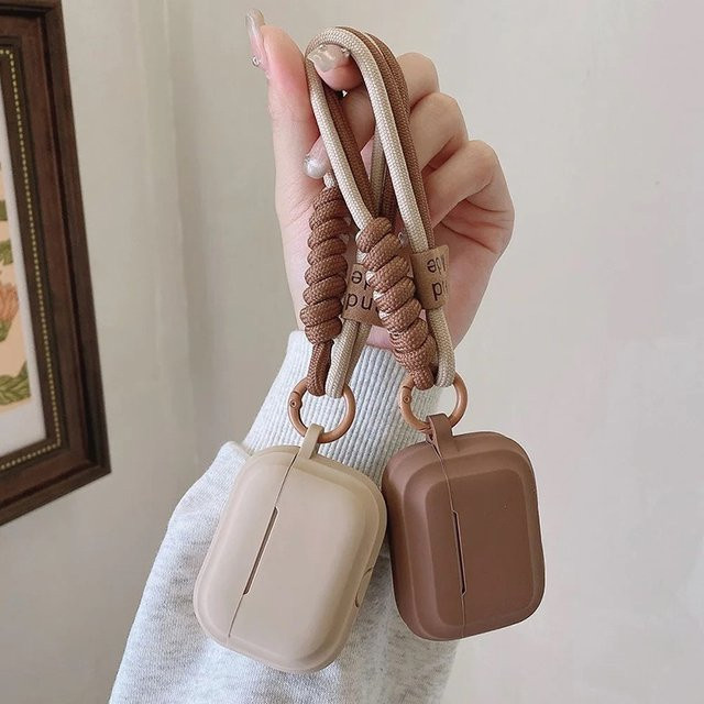 Karamellfarbene Silikon-Schutzhülle mit Umhängeband für Apple AirPods 4, 3 sowie Pro 1 und 2 in Beige oder Braun - Bild 1