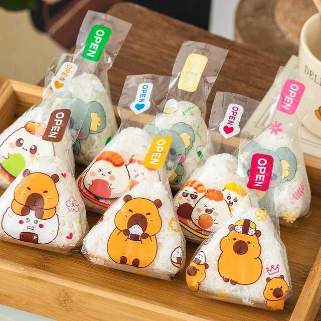 50 oder 100 Stück transparente Dreieck Onigiri Sushi Taschen mit Cartoon Capybara Motiv aus Kunststoff für Bento und Reisbälle - Bild 1