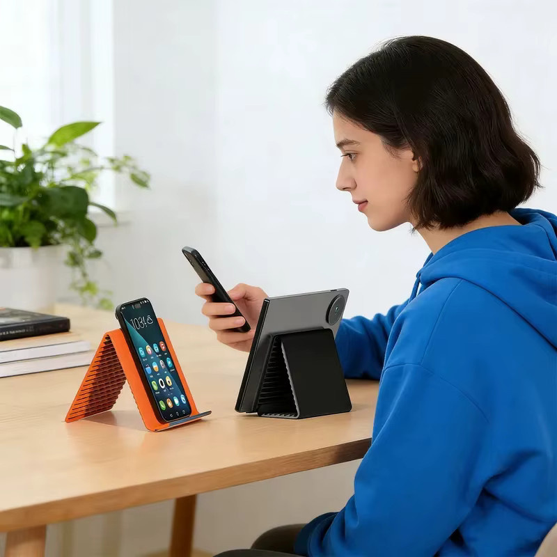Tragbarer faltbarer Silikon-Handyhalter von Tutew in Schwarz oder Orange, flexibler und mehrfach verstellbarer Handyständer - Bild 2