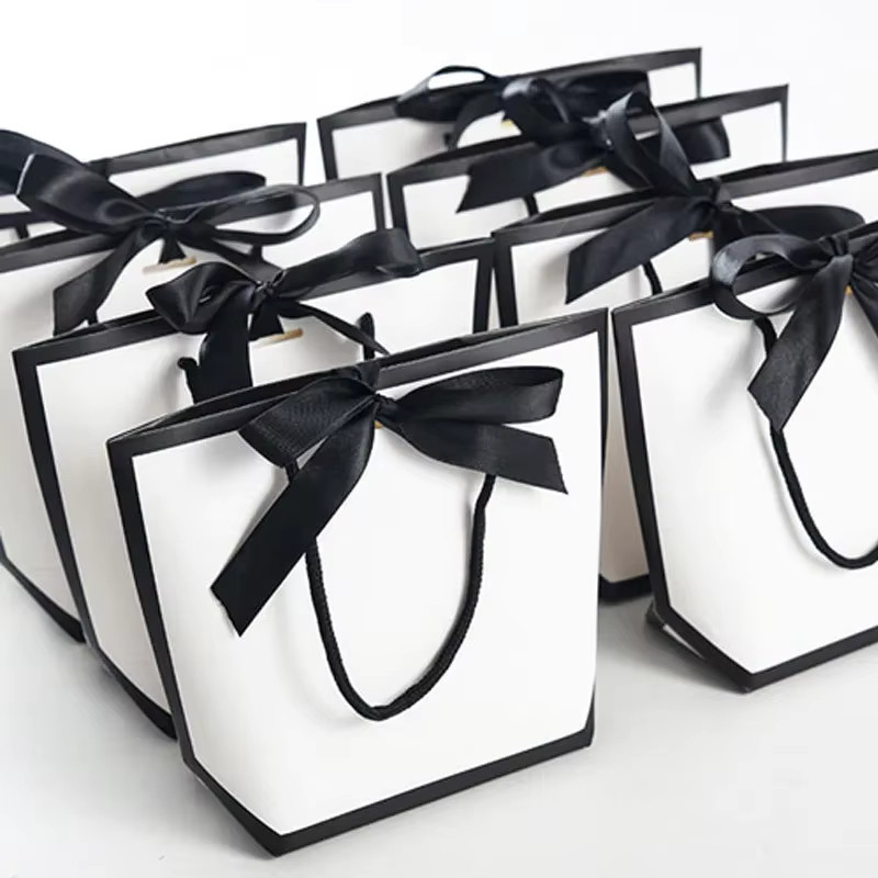Weiße Geschenktüten aus Papier mit Schleife und Griffen für Hochzeiten, Geburtstage und Partys - Bild 2