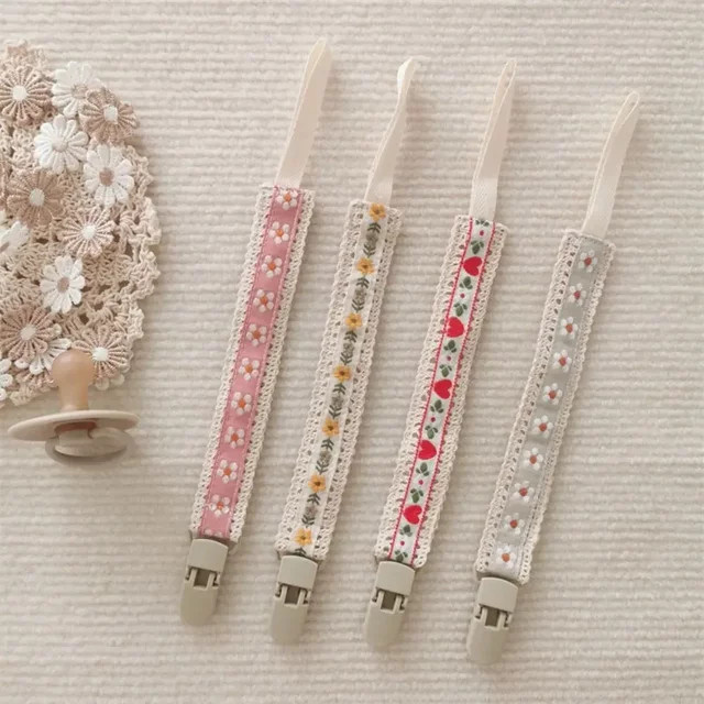 Baby Schnullerkette mit Blumen-Stickerei und Kunststoff-Clip in Gelb und Mehrfarbig - Bild 1