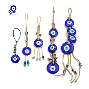Handgefertigter Lucky Eye Wandbehang aus Makramee und Glas in Blau mit Herz und Kreuz Motiven