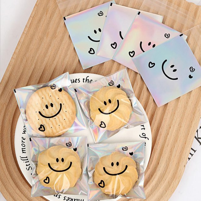 100 Stück transparente Laser-Keksbeutel mit selbstklebendem Verschluss und süßem Smiley-Motiv für Geburtstage und Partys - Bild 1